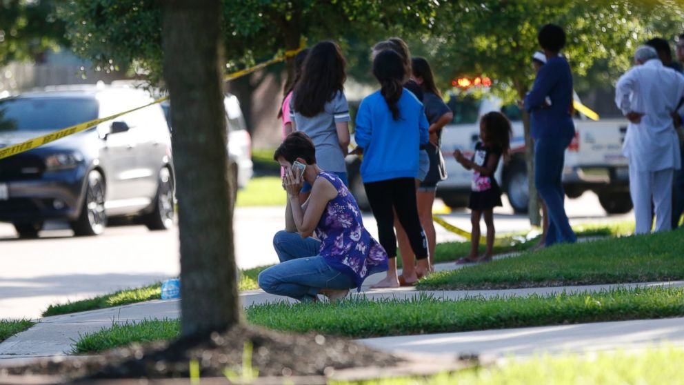 PHOTO: Neighbors gather to watch as Fort Bend County Sheriffs department investigates a scene where a woman shot her two adult daughters before she was fatally shot by a responding police officer, June 24, 2016.